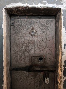 A bolted and locked prison cell door.